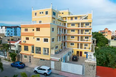 a yellow building with cars parked in front of it at Spacious 2Br 1Bath Apartment Terrace & Street View in La Viva