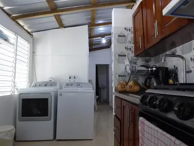 a kitchen with a stove and a washer and dryer at Cozy Studios-Private Entrance- HS Internet-AC-Hot Water-Backup Generator-near the Beach in San Felipe de Puerto Plata