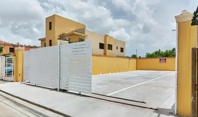 a gate in a parking lot in front of a building at 1 Bedroom Apartment 1 Queen 2 Singles in La Viva