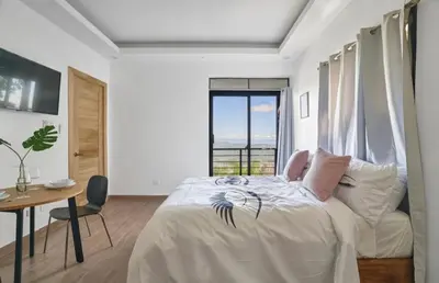 a bedroom with a bed and a table and a window at Villa Favella-Pop-Art-View-7BR-Jamaca De Dios-Balcony-Dream in Jarabacoa