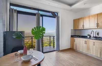 a kitchen with a table and a large window at Villa Favella-Pop-Art-View-7BR-Jamaca De Dios-Balcony-Dream in Jarabacoa