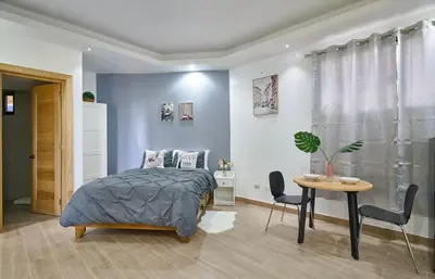 a bedroom with a bed and a table and chairs at Villa Favella-Pop-Art-View-7BR-Jamaca De Dios-Balcony-Dream in Jarabacoa