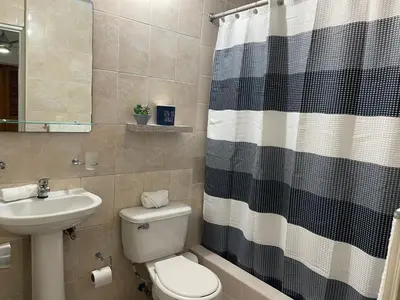 a bathroom with a sink and a toilet and a shower curtain at Hospedaje de marant 1 in San Felipe de Puerto Plata