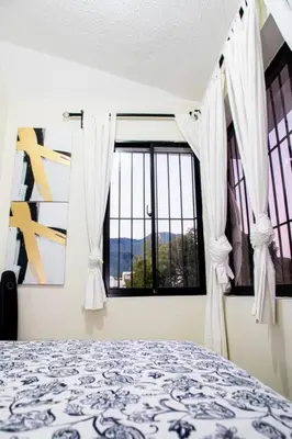 a bedroom with a bed and a large window at El más completo, a menos de 5 minutos de la playa, free wifi fuera del alojamiento in San Felipe de Puerto Plata