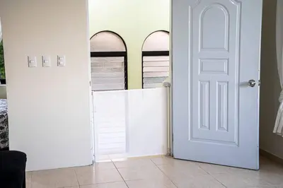 a white door in a room with two windows at El más completo, a menos de 5 minutos de la playa, free wifi fuera del alojamiento in San Felipe de Puerto Plata