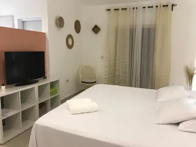 a bedroom with a white bed with a tv on it at Beautiful Villa in Boca Chica in Boca Chica