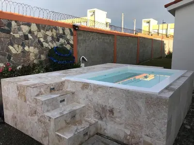 a large stone bathtub in a yard with a fence at Beautiful Villa in Boca Chica in Boca Chica
