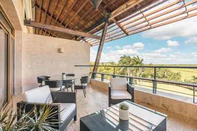 an outdoor patio with a table and chairs and a view at Golf View Apt at Casa De Campo in El Infiernito