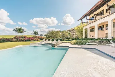 a swimming pool in front of a building at Golf View Apt at Casa De Campo in El Infiernito