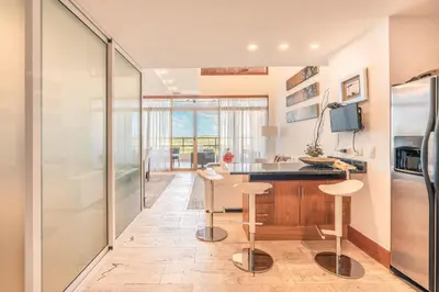 a kitchen with a counter and stools in a room at Golf View Apt at Casa De Campo in El Infiernito
