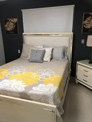 a bedroom with a bed with a yellow and white comforter at Residencial PALMA REAL in Santiago de los Caballeros