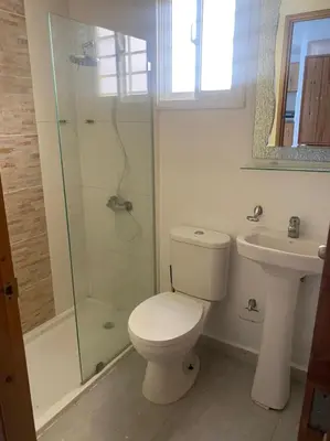 a bathroom with a toilet and a shower and a sink at Residencial PALMA REAL in Santiago de los Caballeros