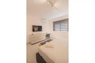 a bedroom with a bed and a desk and a tv at SOHA PANORAMA in Santiago de los Caballeros