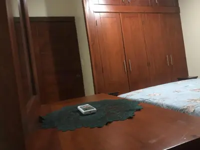 a room with a table and a bed and a wooden cabinet at Apartamentos Kika in San Felipe de Puerto Plata