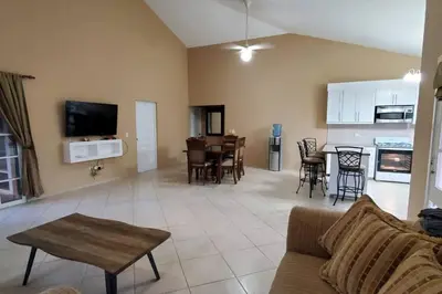 a living room with a couch and a table and a kitchen at Charming 3 bedroom villa 66 with private pool in Sosúa
