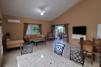 a living room with a table and chairs at Charming 3 bedroom villa 66 with private pool in Sosúa