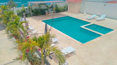 an overhead view of a swimming pool with chairs and trees at Gaviota Paradise in La Romana