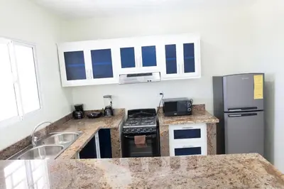 a kitchen with granite counter tops and a refrigerator at Gaviota Paradise in La Romana