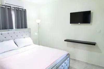 a bedroom with a bed and a flat screen tv at Gaviota Paradise in La Romana