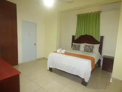 a bedroom with a bed with a green curtain at Hotel Enrique I Gazcue, Bed and Breakfast in Santo Domingo