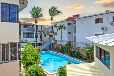 an apartment with a swimming pool and palm trees at One Bedroom Apartment in Sosua , Great for Remote Workers Fast Wifi in Sosúa