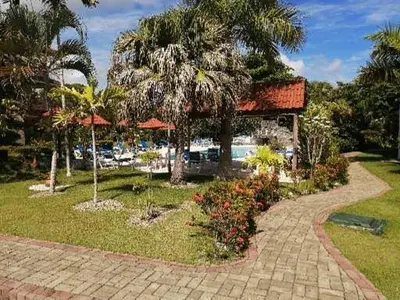 a resort with a walkway and palm trees and a building at Hermoso apartamento de playa en perla marina Sosua - Cabarete in Sosúa