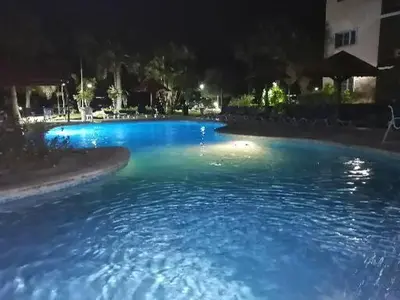 a large pool of blue water at night at Hermoso apartamento de playa en perla marina Sosua - Cabarete in Sosúa