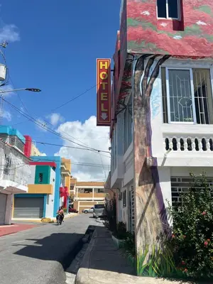 a building with a sign on the side of a street at Hotel María Bonita Higüey, Apartments in Higuey