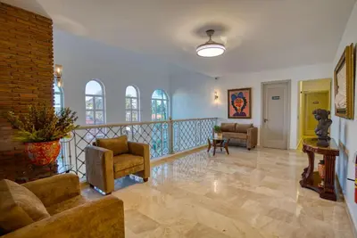 a living room with couches and a staircase at Naranjo Hotel Boutique in Higuey