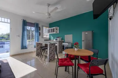 a kitchen and living room with a table and chairs at EDMA APARTAHOTEL in Santa Bárbara de Samaná