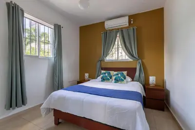 a bedroom with a large bed with blue pillows at EDMA APARTAHOTEL in Santa Bárbara de Samaná