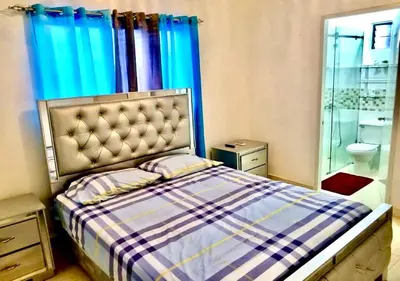 a bedroom with a bed and a glass shower at Acogedor apartment , seguridad las 24 horas , Cibao International Airport 8 minutos, Centro de Santiago 10 Minutos , Tamboril la capital mundial del cigarro 10 minutos in Licey al Medio