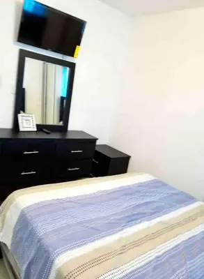 a bedroom with a bed and a dresser with a mirror at Acogedor apartment , seguridad las 24 horas , Cibao International Airport 8 minutos, Centro de Santiago 10 Minutos , Tamboril la capital mundial del cigarro 10 minutos in Licey al Medio