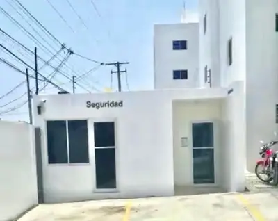 a white building with a motorcycle parked in front of it at Acogedor apartment , seguridad las 24 horas , Cibao International Airport 8 minutos, Centro de Santiago 10 Minutos , Tamboril la capital mundial del cigarro 10 minutos in Licey al Medio