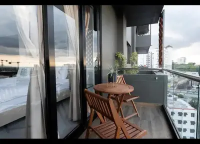 a balcony with a table and chairs and a bed at Torre Rialto in Santiago de los Caballeros