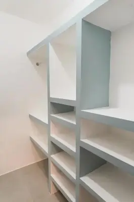 a walk in closet with white shelves at Torre Rialto in Santiago de los Caballeros