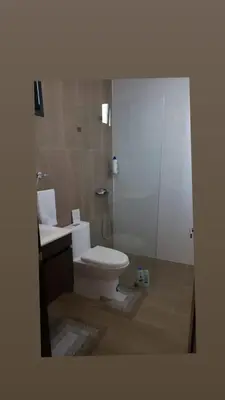 a bathroom with a toilet and a sink and a shower at Torre Rialto in Santiago de los Caballeros
