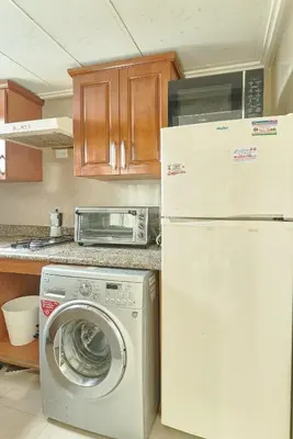 a kitchen with a washing machine and a refrigerator at Exquisite Oceanfront Suite in Santo Domingo