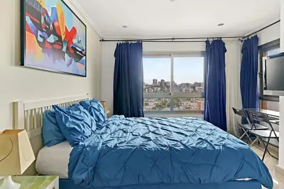 a bedroom with a blue bed and a window at Exquisite Oceanfront Suite in Santo Domingo