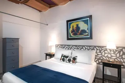 a bedroom with a bed and a painting on the wall at PH 19 Guesthouse Hotel in Gazcue in Santo Domingo