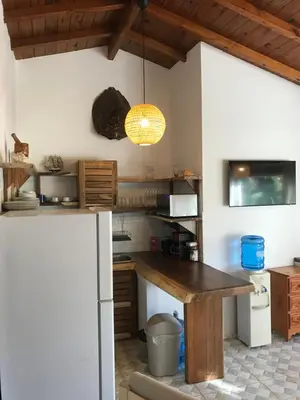 a kitchen with a wooden table and a refrigerator at La Cortesana Cozy Apt Steps to the Beach in Las Terrenas