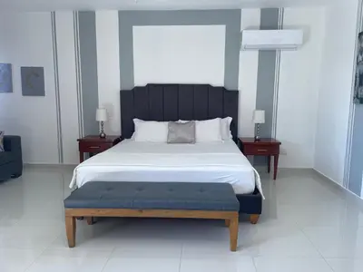 a bedroom with a large bed with a blue bench at Gaia Residence Deluxe in San Felipe de Puerto Plata