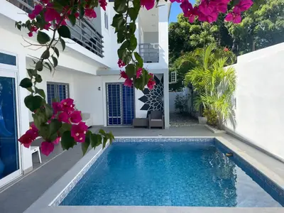 a villa with a swimming pool and flowers at Gaia Residence Deluxe in San Felipe de Puerto Plata