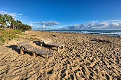 a picnic table and bench on a sandy beach at Amazing ocean view apartment with grand pool in Cabarete