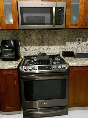 a kitchen with a stove and a microwave at Spectacular PentHouse with private jacuzzi terrace in Santiago de los Caballeros