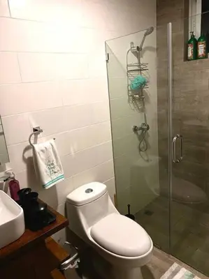 a bathroom with a toilet and a glass shower at Spectacular PentHouse with private jacuzzi terrace in Santiago de los Caballeros