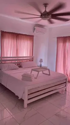 a bedroom with a large bed with a ceiling fan at 5 Star Villa minutes from Airport and Beaches in Sosúa