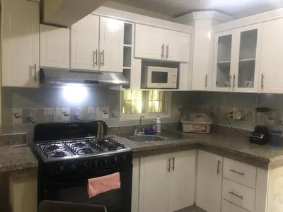 a kitchen with white cabinets and a stove top oven at Apartamento CGM de 1 habitación in La Romana
