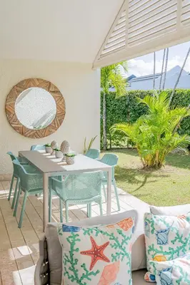 a patio with a table and chairs and a mirror at Xeliter Green One Playa Dorada in San Felipe de Puerto Plata