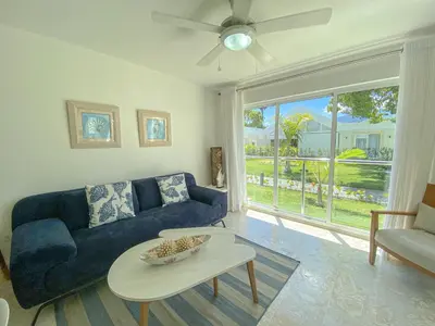 a living room with a blue couch and a table at Xeliter Green One Playa Dorada in San Felipe de Puerto Plata